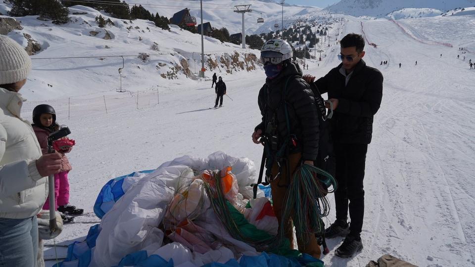 Kayakçılar pistte, kadın milli paraşütçü havada