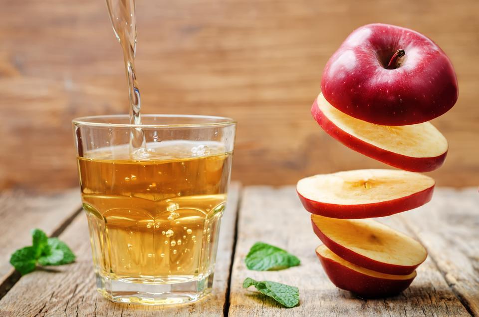 flying slices of apple and apple juice on a dark wood background. toning. selective Focus