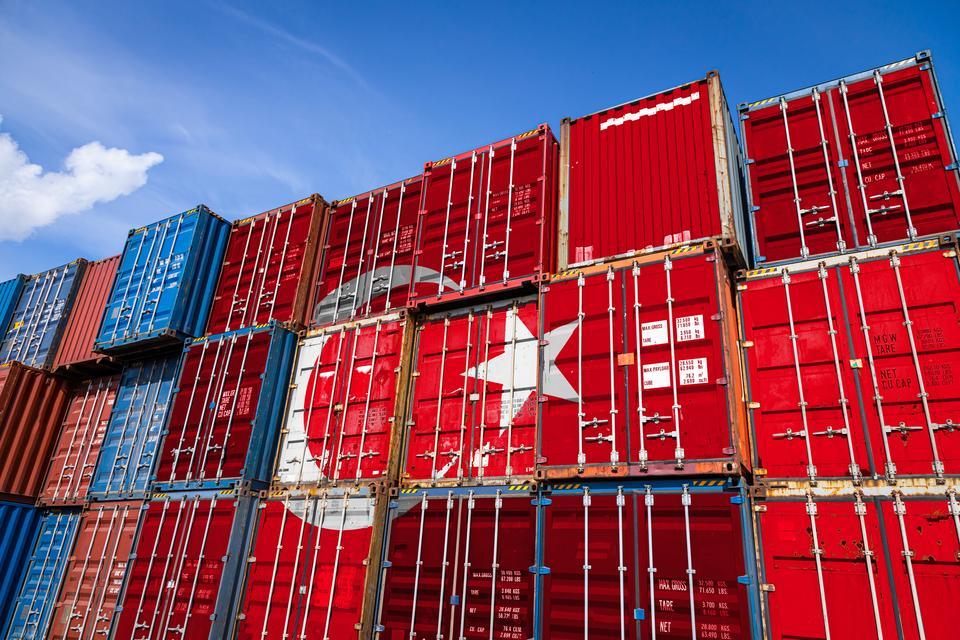 The national flag of Turkey on a large number of metal containers for storing goods stacked in rows on top of each other. Conception of storage of goods by importers, exporters