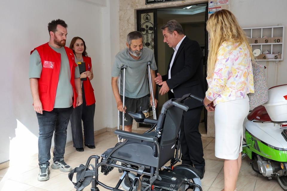 Başkan Yetişkin Özcal’ın akülü sandalyesini evinde teslim etti