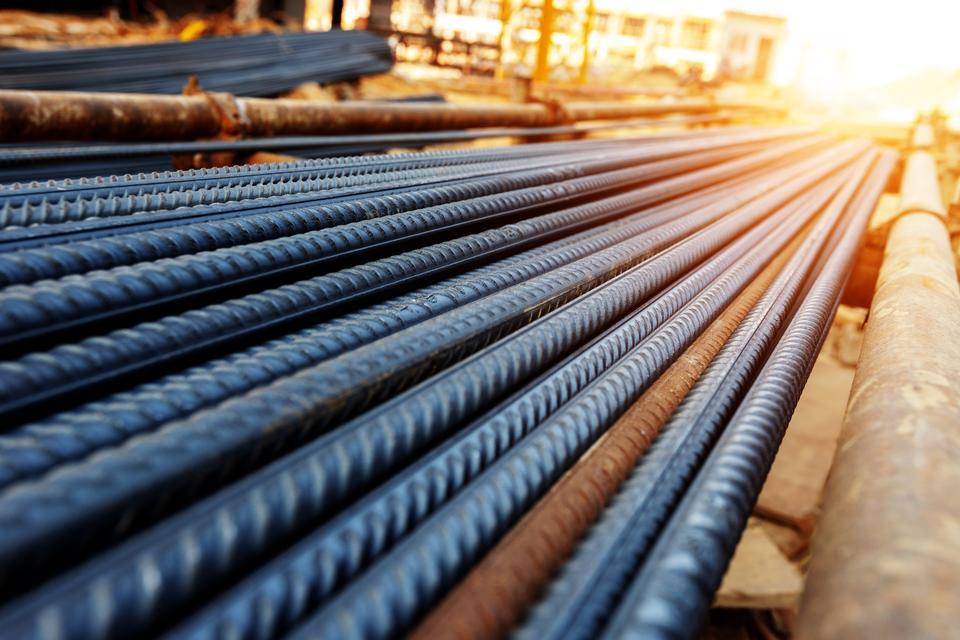 steel rebar for reinforcement concrete at construction site with house under construction background